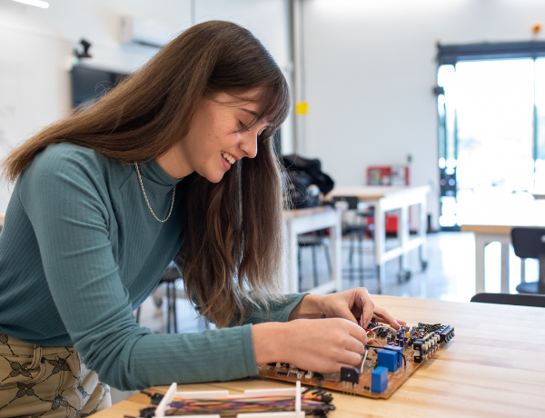 female electrical engineering student working on device